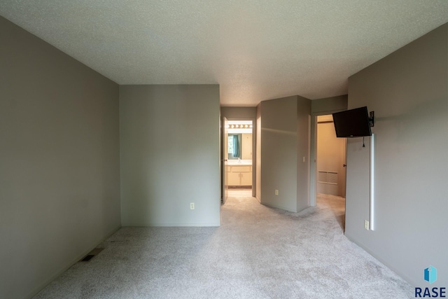 carpeted spare room featuring a textured ceiling