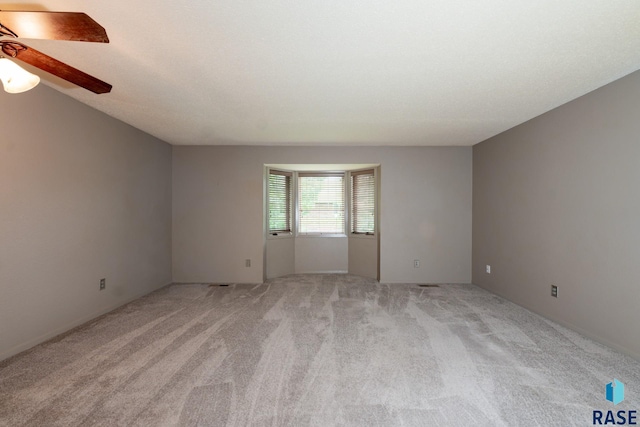 spare room with light carpet and ceiling fan