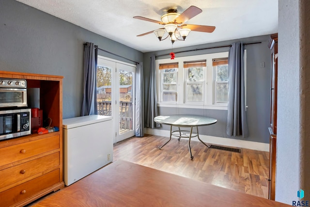 doorway to outside with ceiling fan and light hardwood / wood-style floors