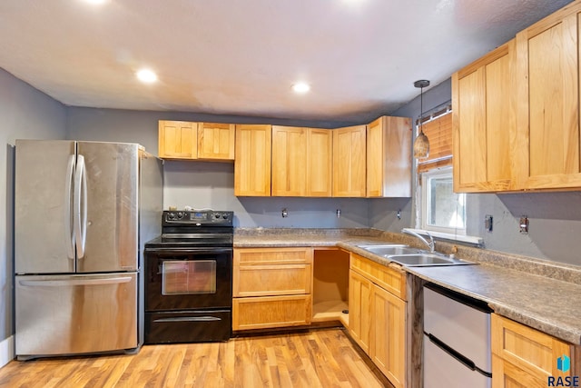 kitchen featuring appliances with stainless steel finishes, light hardwood / wood-style floors, hanging light fixtures, and sink