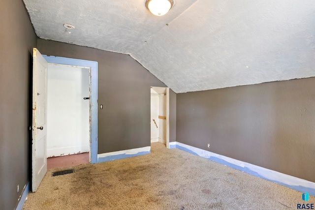 bonus room with carpet flooring, a textured ceiling, and vaulted ceiling