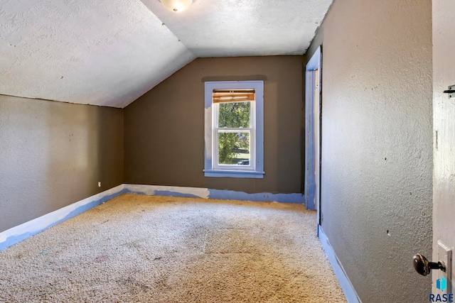 bonus room with carpet flooring, a textured ceiling, and vaulted ceiling