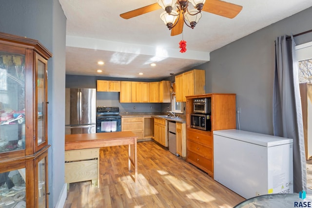 kitchen with light wood-type flooring, stainless steel appliances, ceiling fan, sink, and light brown cabinets