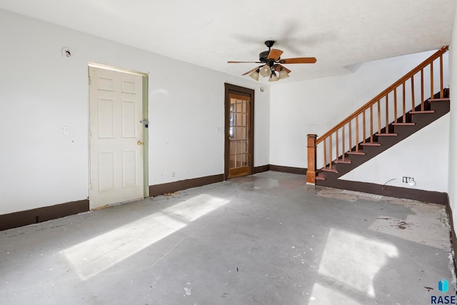 unfurnished living room featuring ceiling fan and concrete flooring