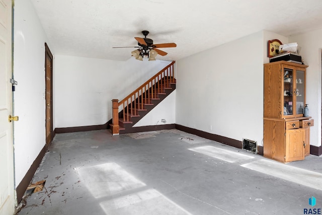 unfurnished living room with ceiling fan, concrete flooring, and a textured ceiling