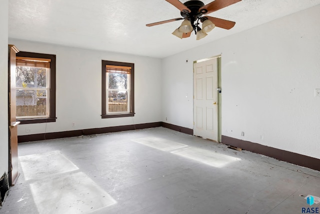 unfurnished room with a textured ceiling, a wealth of natural light, and ceiling fan