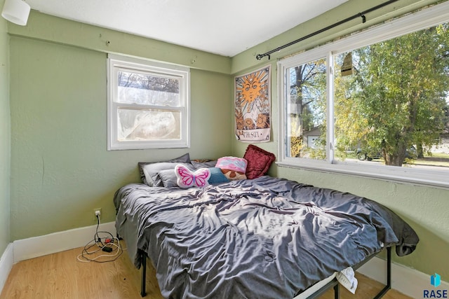 bedroom featuring hardwood / wood-style floors and multiple windows