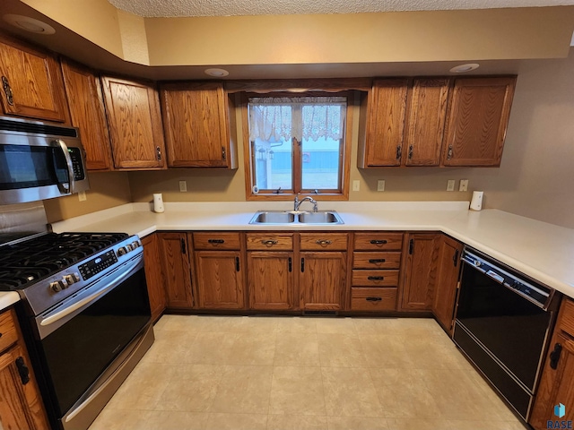 kitchen featuring a textured ceiling, sink, and appliances with stainless steel finishes