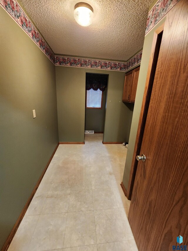 hall with a textured ceiling