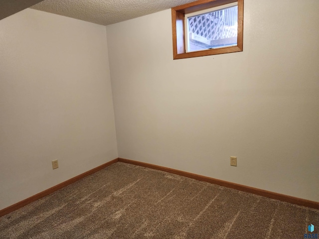 carpeted spare room featuring a textured ceiling