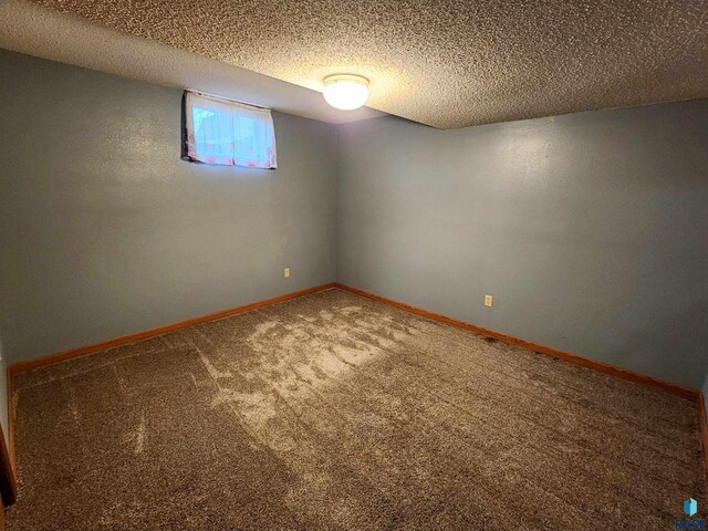 carpeted spare room featuring a textured ceiling