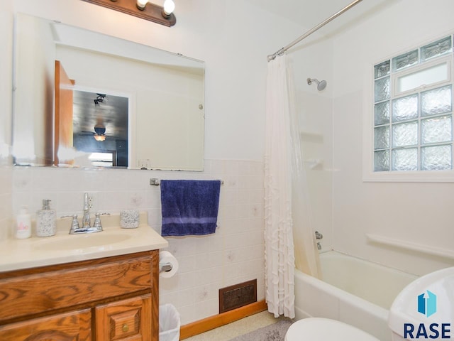 full bathroom with tile walls, vanity, shower / bath combo, and toilet