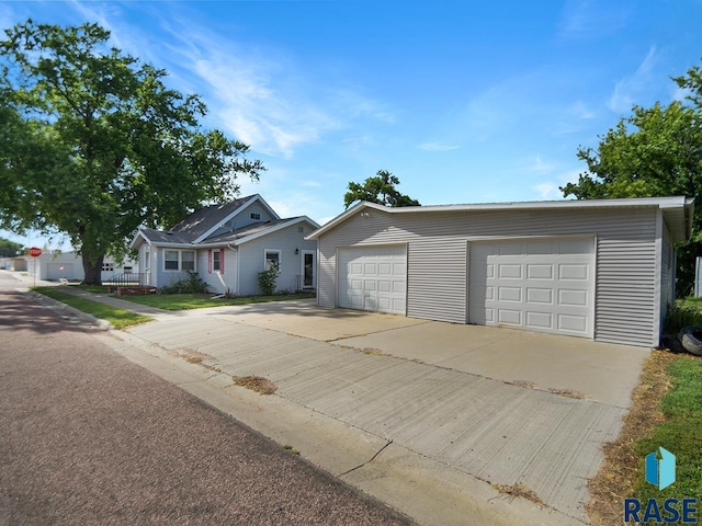 single story home featuring a garage and an outbuilding