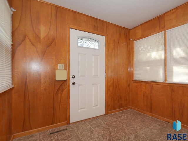 foyer entrance featuring wood walls