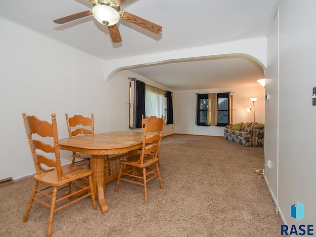 carpeted dining room with ceiling fan