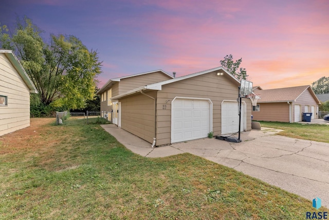 property exterior at dusk featuring a yard and a garage