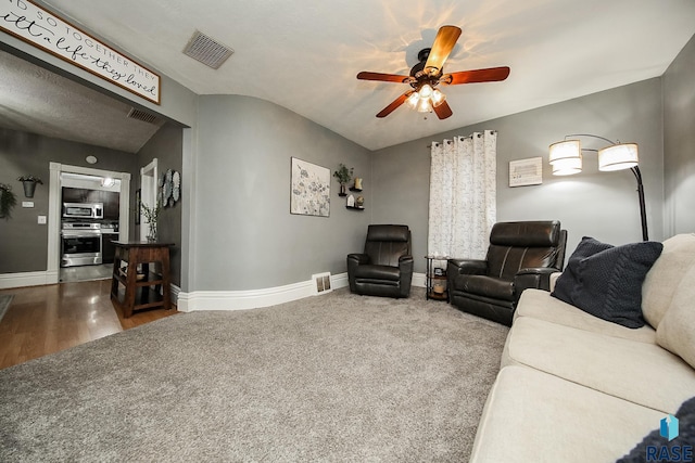 living room featuring ceiling fan, hardwood / wood-style floors, and a textured ceiling