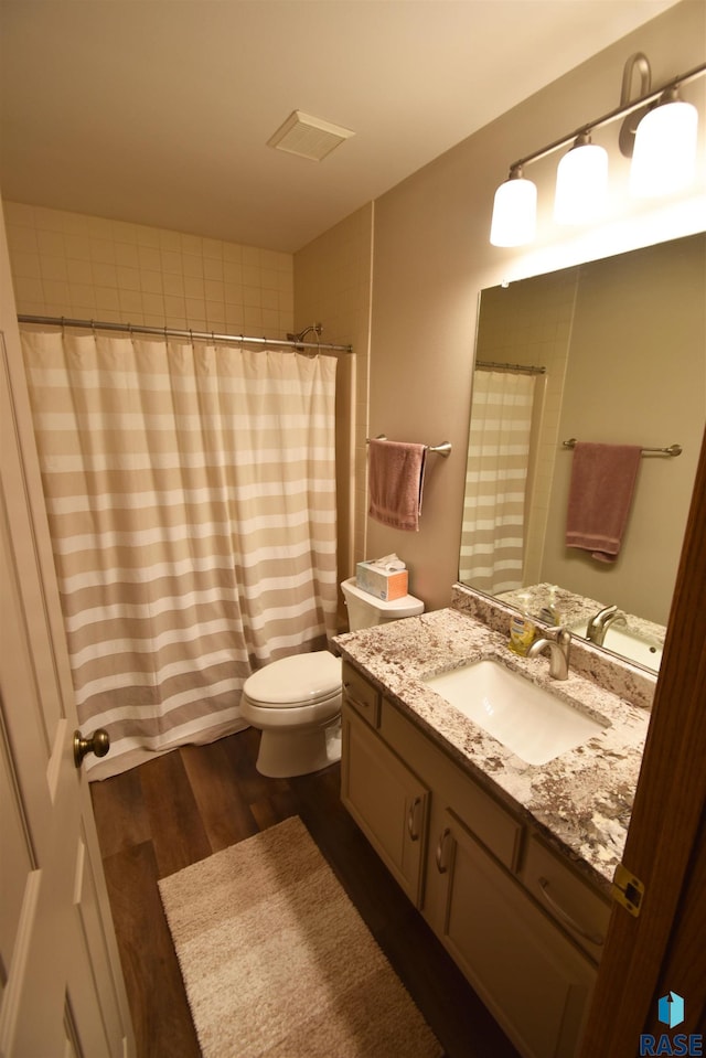 bathroom with vanity, toilet, wood-type flooring, and walk in shower