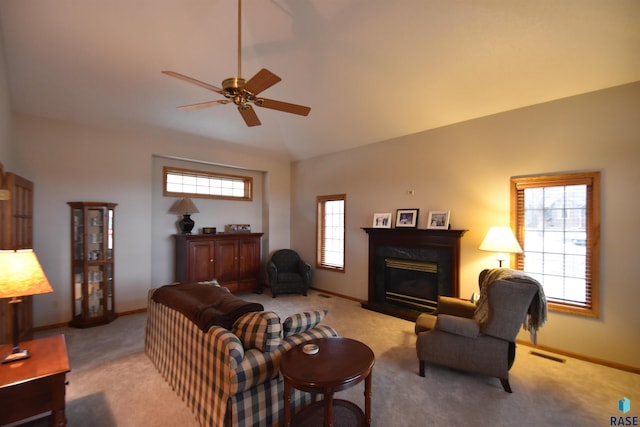 carpeted living room featuring ceiling fan, lofted ceiling, a fireplace, and a wealth of natural light