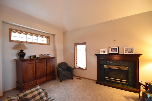 sitting room featuring a premium fireplace and light colored carpet