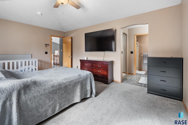 carpeted bedroom featuring ensuite bath and ceiling fan