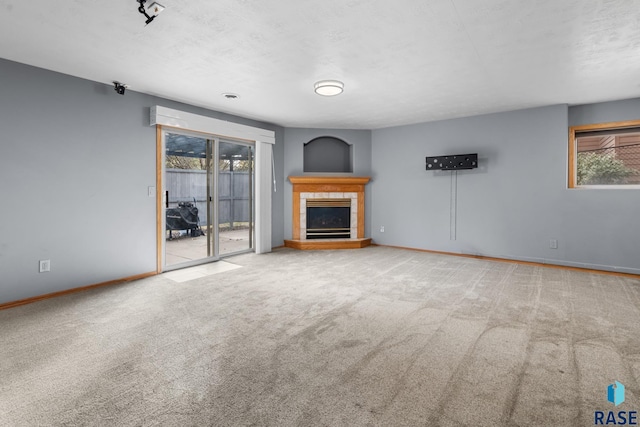 unfurnished living room featuring carpet flooring, a fireplace, and a textured ceiling