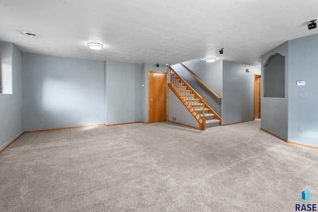 spare room with light colored carpet and a textured ceiling