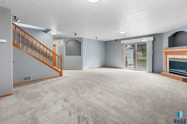 unfurnished living room featuring a textured ceiling and carpet floors