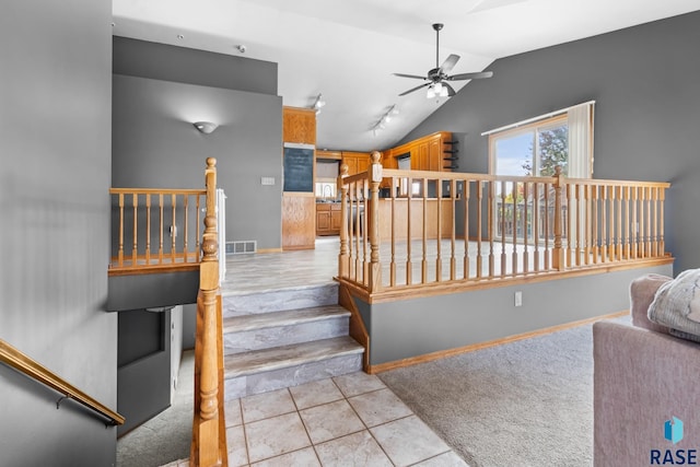 staircase with tile patterned flooring, ceiling fan, sink, and vaulted ceiling