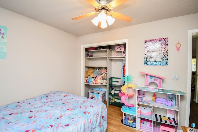 bedroom with hardwood / wood-style floors, a textured ceiling, a closet, and ceiling fan