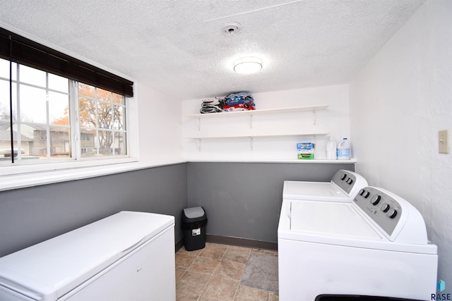 laundry area featuring a textured ceiling and washer and clothes dryer