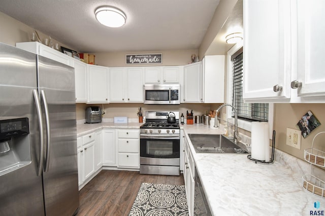 kitchen featuring white cabinets, stainless steel appliances, dark wood-type flooring, and sink