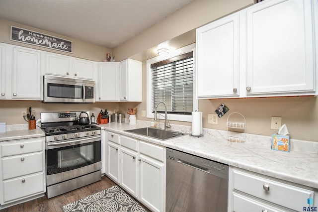 kitchen featuring white cabinets, sink, appliances with stainless steel finishes, and dark wood-type flooring