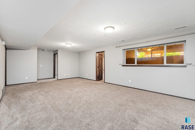 spare room with carpet and a textured ceiling