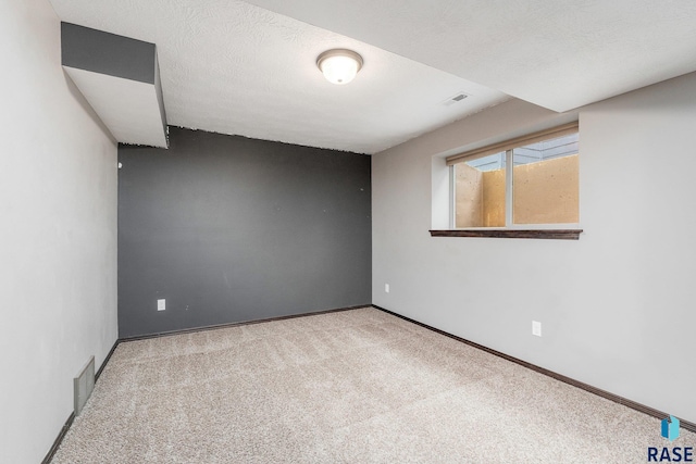 carpeted empty room with a textured ceiling