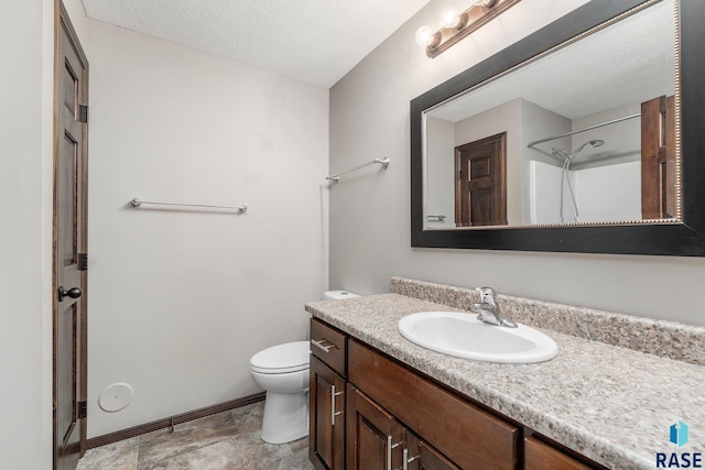 bathroom featuring a textured ceiling, vanity, toilet, and walk in shower