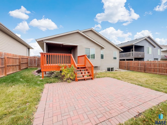 back of property featuring a patio area, a deck, and a yard