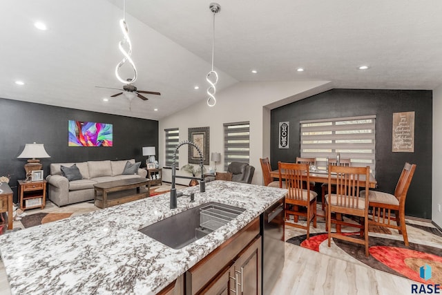 kitchen featuring light stone countertops, ceiling fan, sink, light hardwood / wood-style flooring, and dishwasher