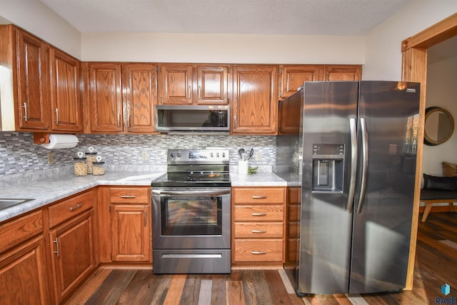 kitchen with decorative backsplash, dark wood-type flooring, and appliances with stainless steel finishes