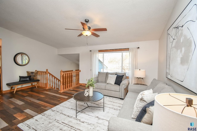 living room with a textured ceiling, dark hardwood / wood-style flooring, and ceiling fan