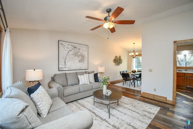 living room featuring ceiling fan with notable chandelier, wood-type flooring, lofted ceiling, and a wealth of natural light