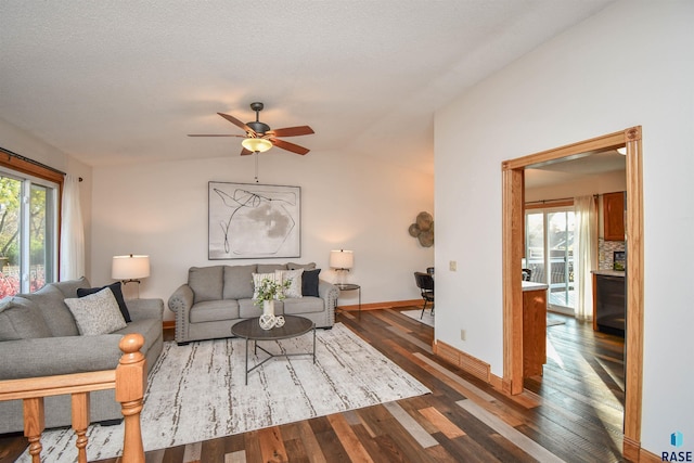 living room featuring a textured ceiling, dark hardwood / wood-style flooring, ceiling fan, and lofted ceiling