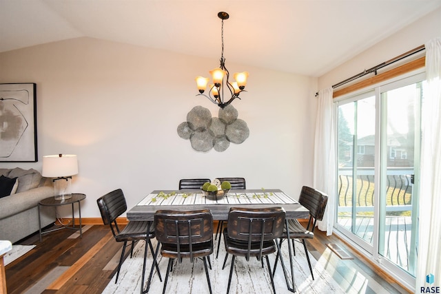 dining space featuring lofted ceiling, dark wood-type flooring, and a notable chandelier