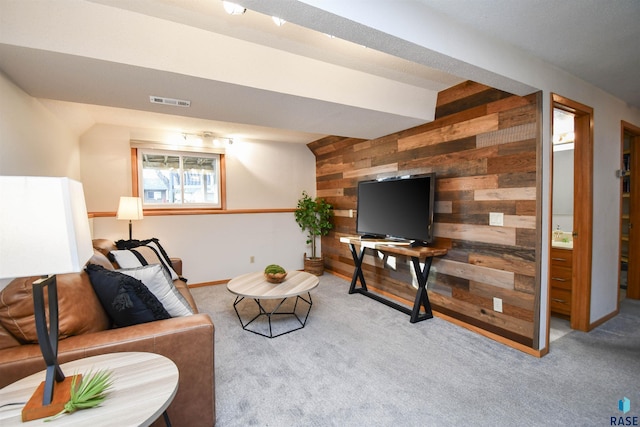 living room with light carpet and wood walls