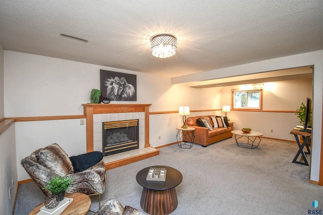 living room featuring carpet, a textured ceiling, and a fireplace