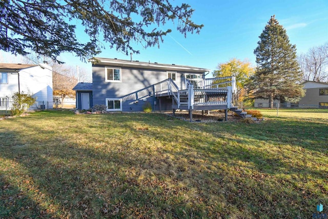 rear view of house with a yard and a deck