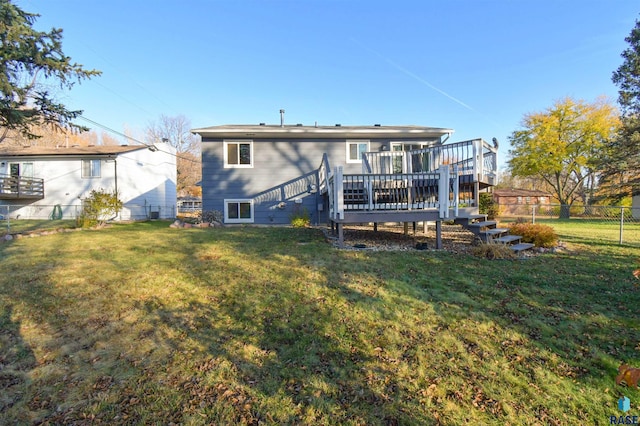 back of property featuring a wooden deck and a yard