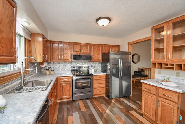 kitchen featuring sink, dark wood-type flooring, stainless steel appliances, tasteful backsplash, and a textured ceiling