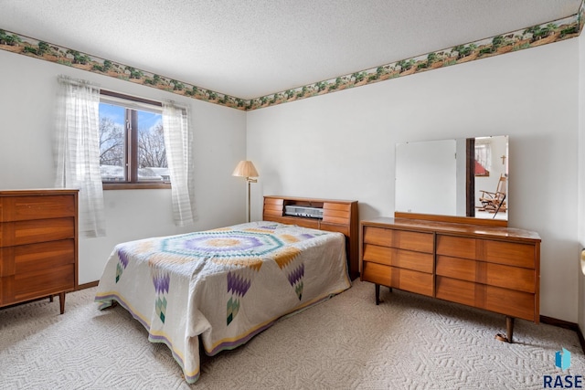 bedroom with light colored carpet and a textured ceiling