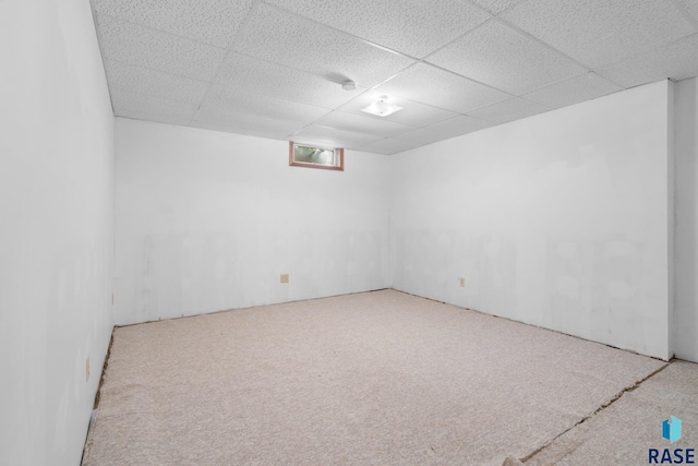 unfurnished room featuring a drop ceiling and carpet